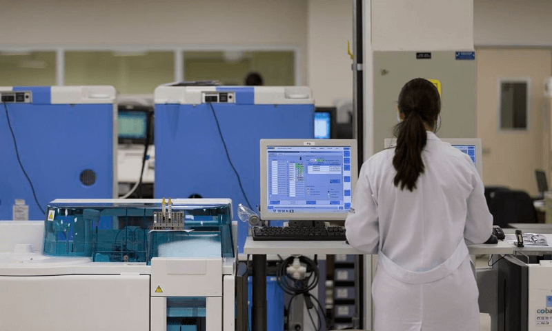 Médica avalia monitor cardíacos em sala de UTI Médica avalia monitor cardíacos em sala de UTI