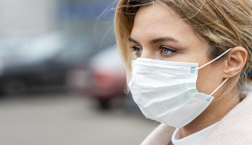 Foto de mulher de máscara em avenida