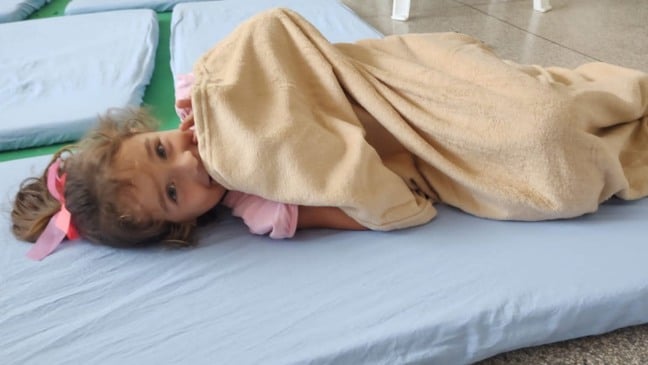 Criança com cobertor em creche