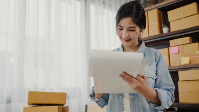 Mulher empresária conferindo caixas de entrega