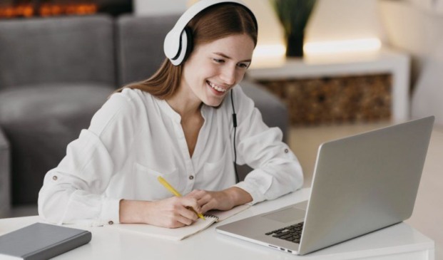 Mulher com caderno em frente à computador