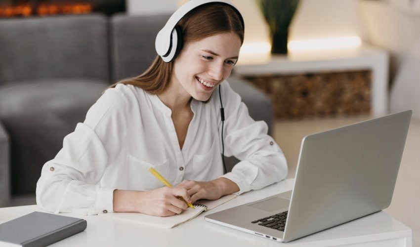 Mulher com caderno em frente à computador
