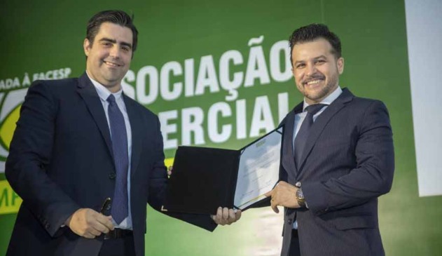 Presidente da Associação Comercial Emrpesarial de Jundiaí Elton Monteiro e o presidente eleito, Mark William Ormenese Monteiro,seguram o termo de posse para a gestão 2020/2021 e d