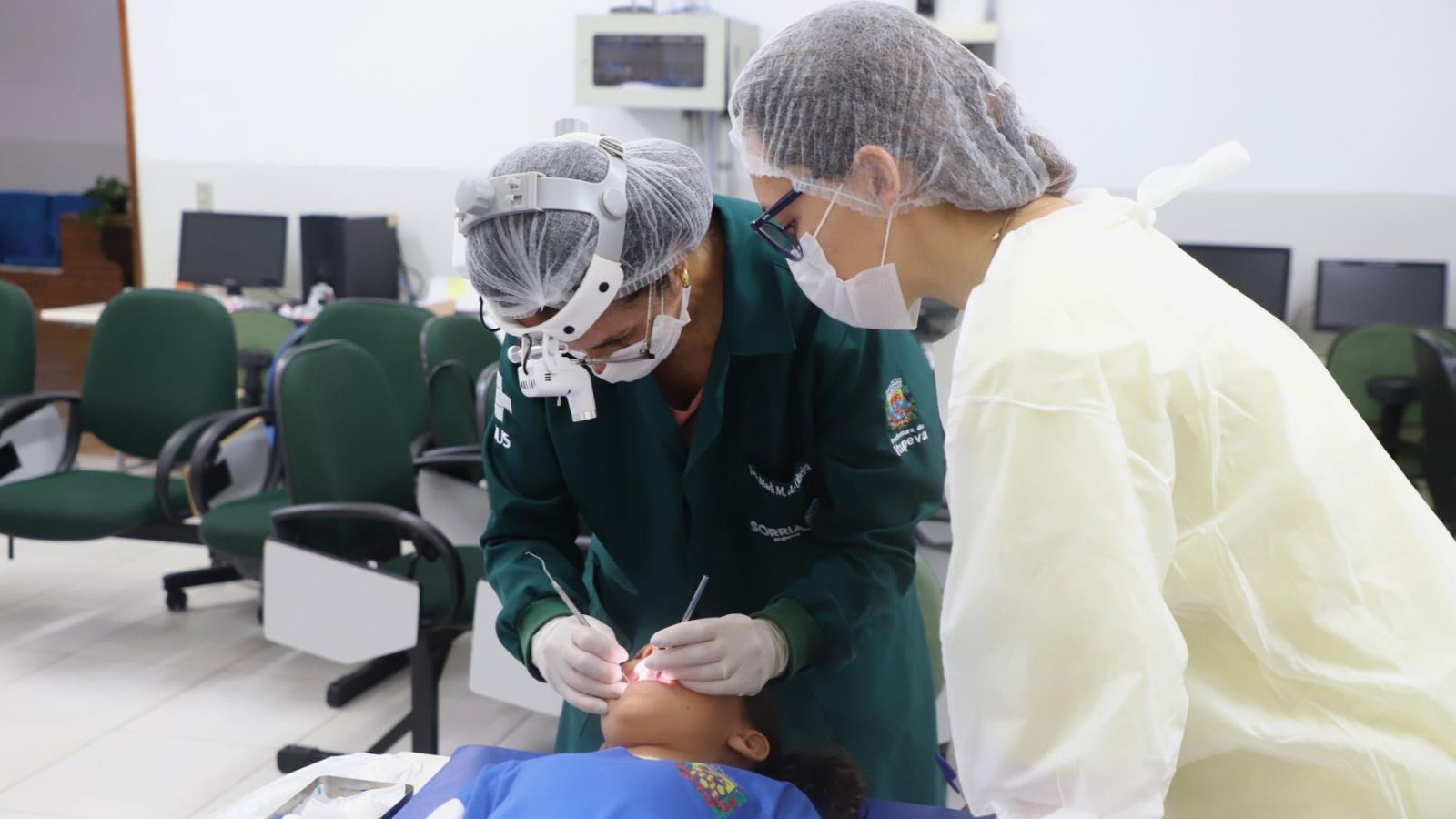 Dentistas examinando a boca de uma estudante