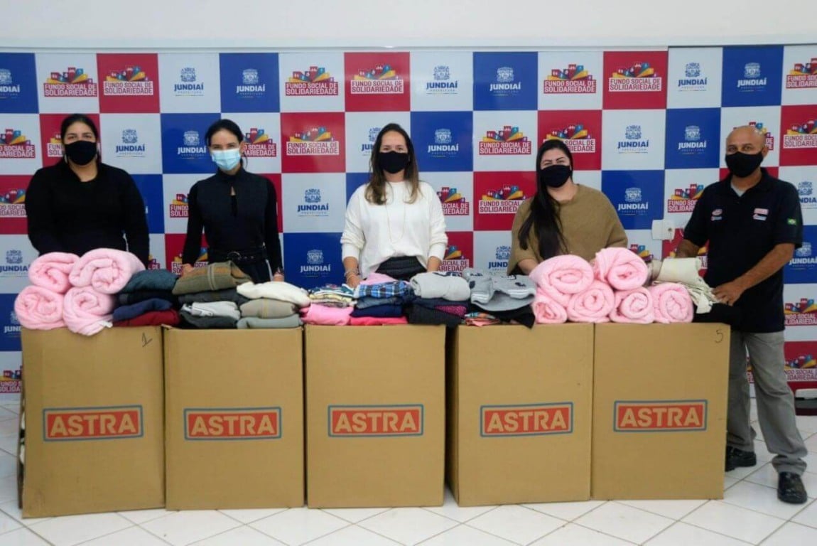 Funcionários do Grupo Astra com caixas de doação de roupas para o Funss