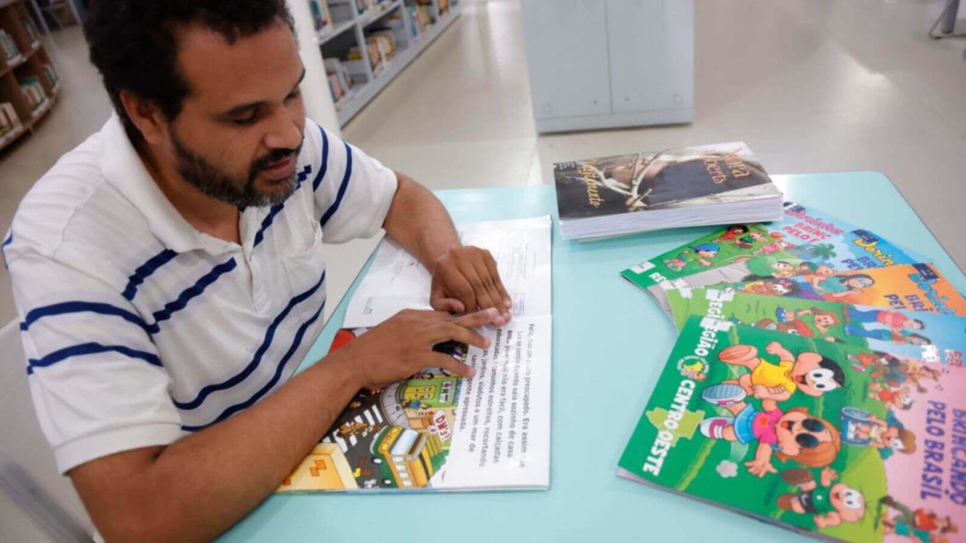 Homem lendo em braille