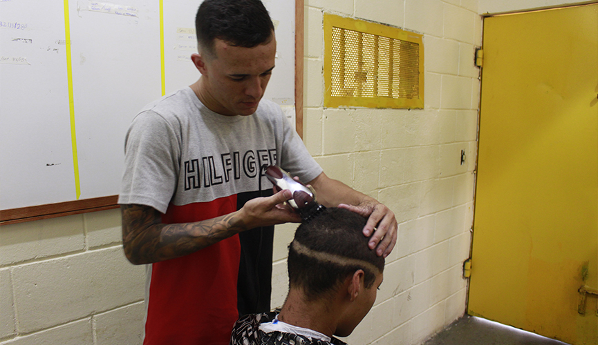 Ex-interno da Fundação Casa e que hoje é cabeleireiro cortando cabelo de interno