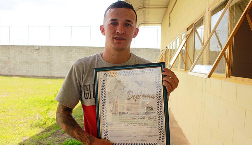 ex-interno da fundação casa segura diploma de cabeleireiro emoldurado