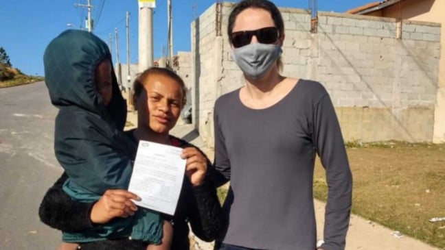 Mulher com criança no colo, ao lado de segunda mulher