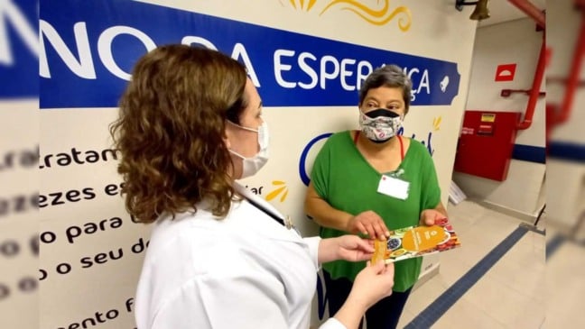 Sra. Maria recebe o manual da enfermeira Flávia