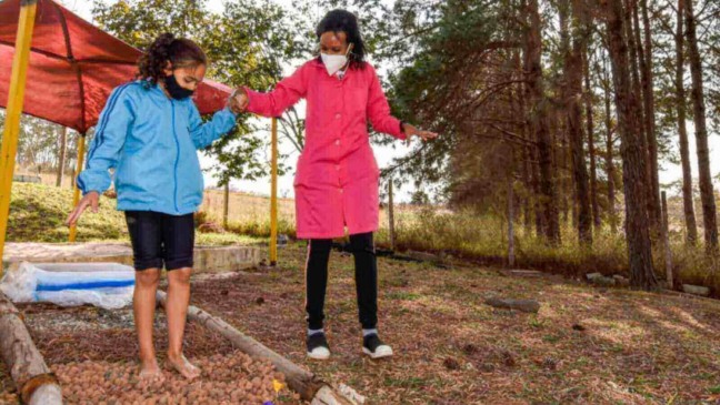 Professora e aluna em trilha sensorial