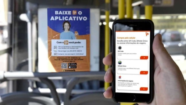 Pessoa segurando celular em ônibus coletivo