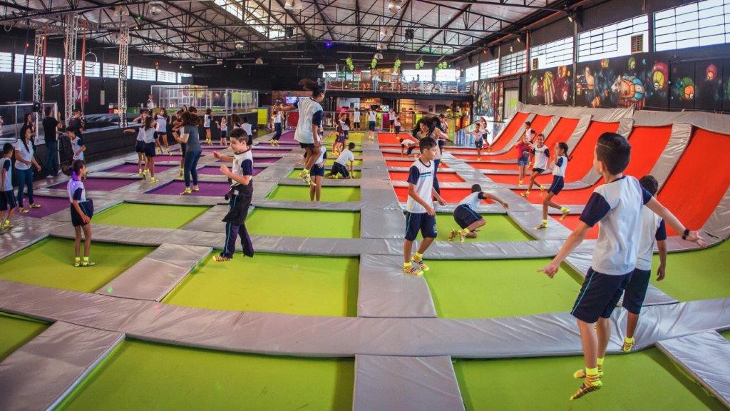 crianças e adolescentes brincado de pular na cama elástica