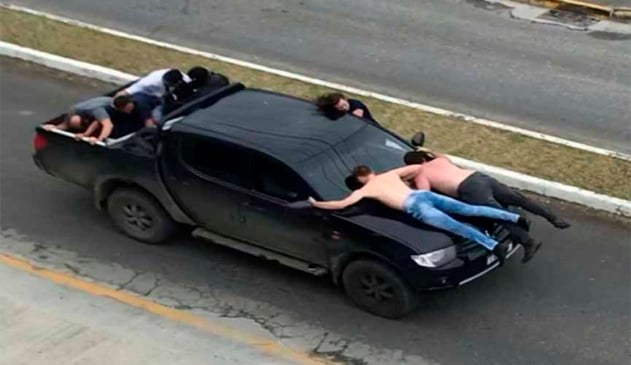 Reféns sobre o capô da caminhonete utilizada na fuga dos criminosos