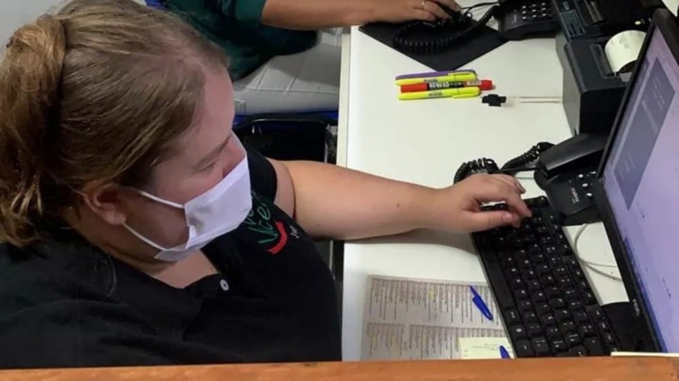 Atendente de pizzaria em frente ao computador