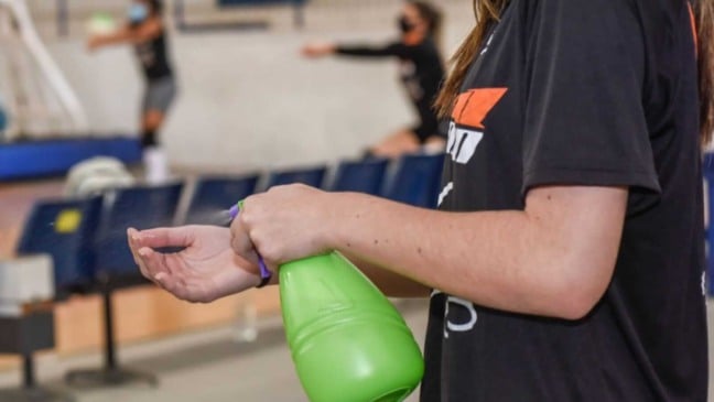 Atleta passando álcool nas mãos