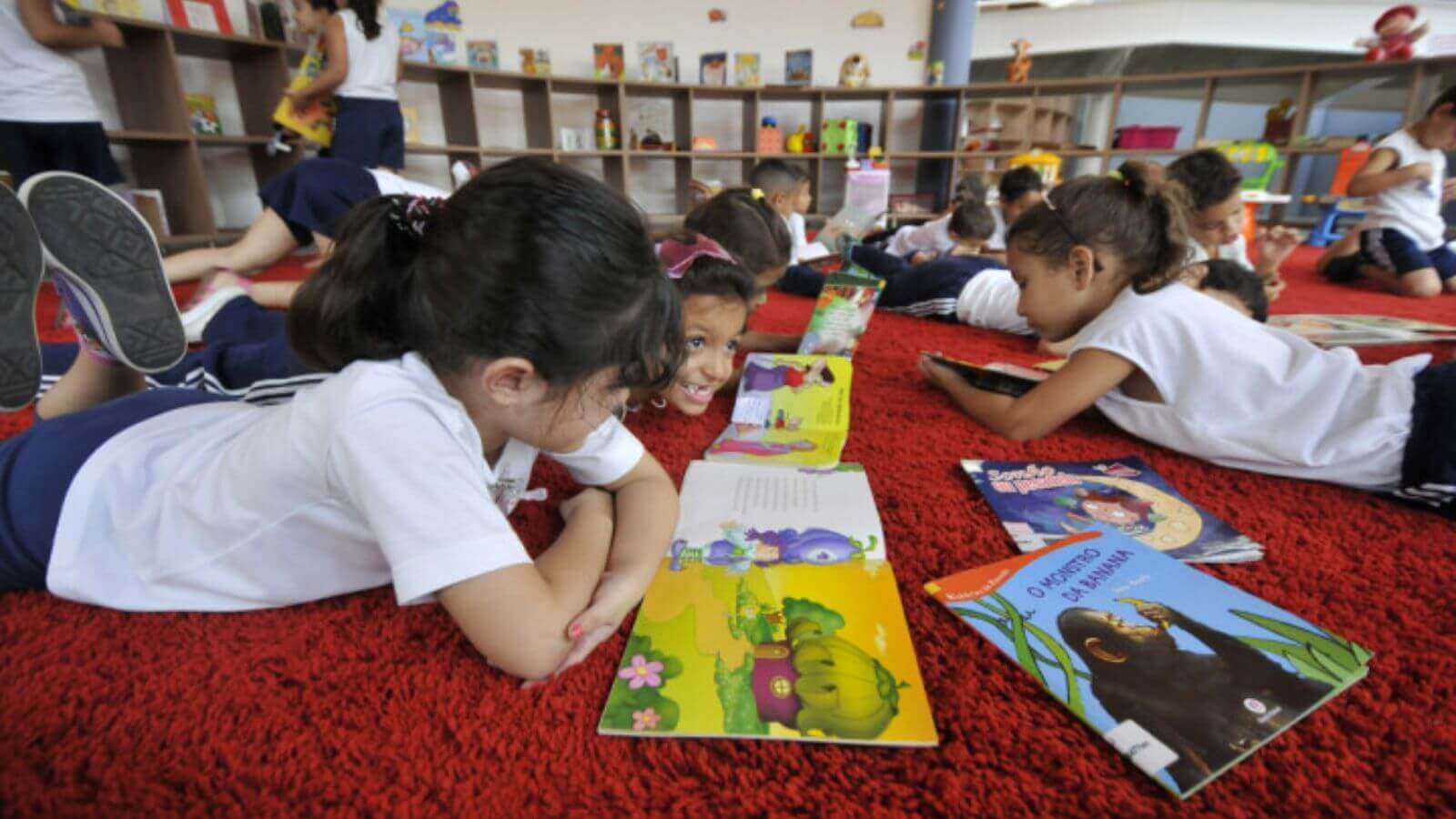 Crianças deitadas no chão da Biblioteca Municipal de Jundiaí