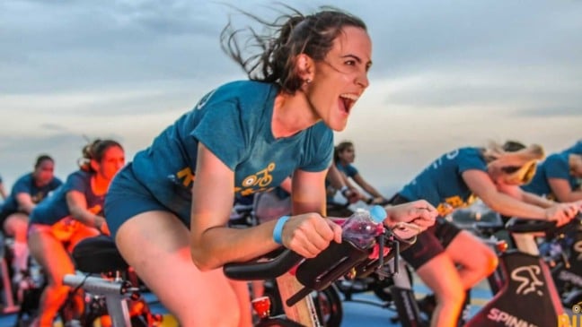 Mulher em bicicleta de academia ao ar livre