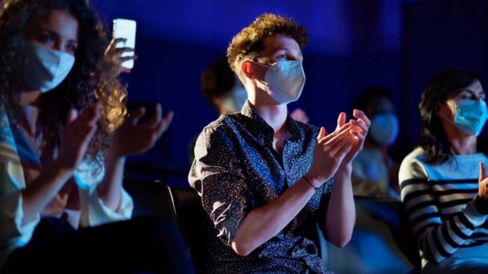 Pessoas em evento, usando máscara