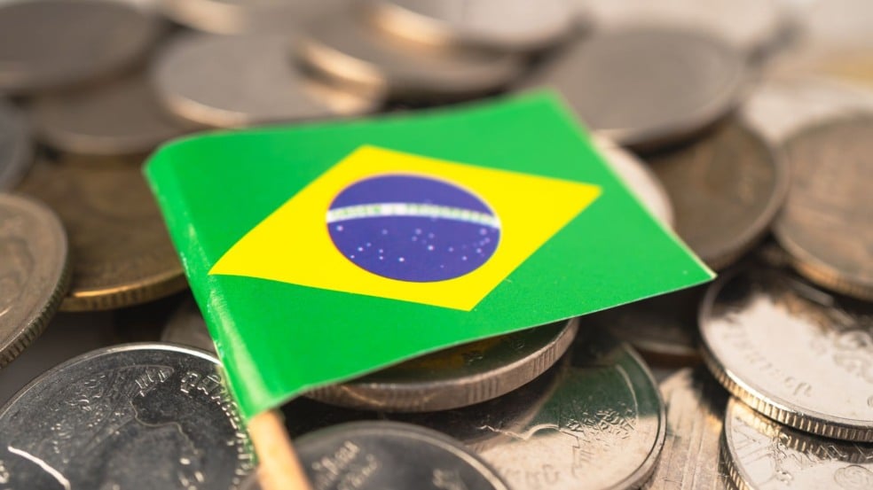 Bandeirinha do brasil no meio de moedas