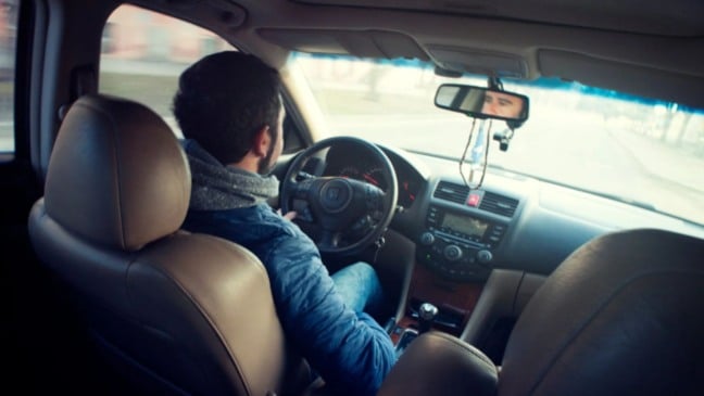 Homem dirigindo veículo.