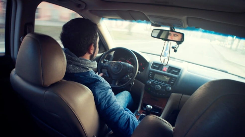 Homem dirigindo veículo.