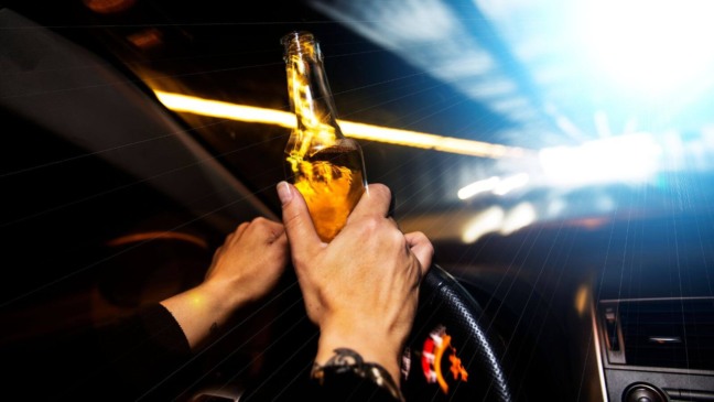 Pessoa com bebida enquanto dirige