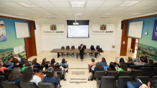 Palestrante fala a profissionais no auditório da Prefeitura de Jundiaí durante encontro sobre saúde do trabalhador.