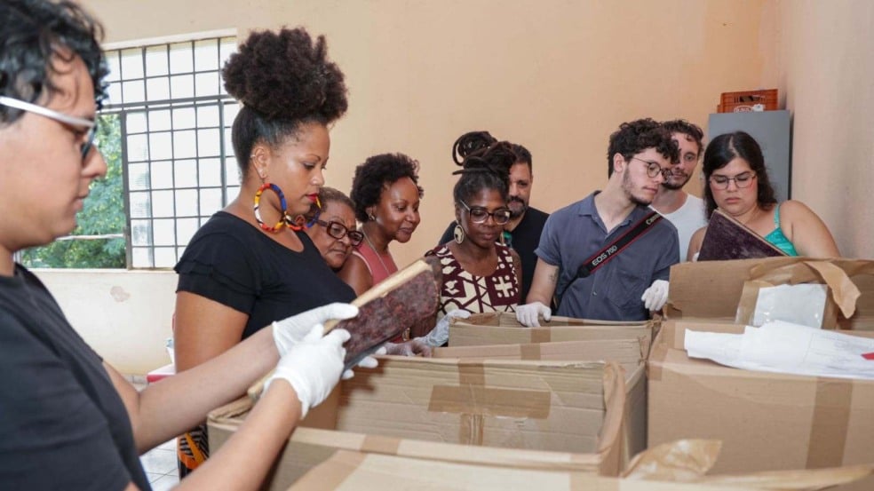 Pessoas analisando acervo histórico.