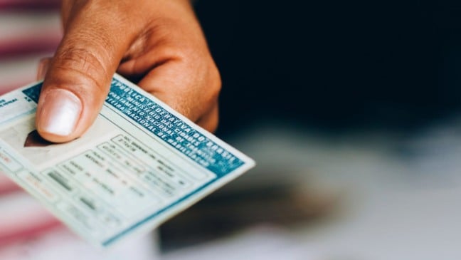 Mulher segurando uma carteira de motorista