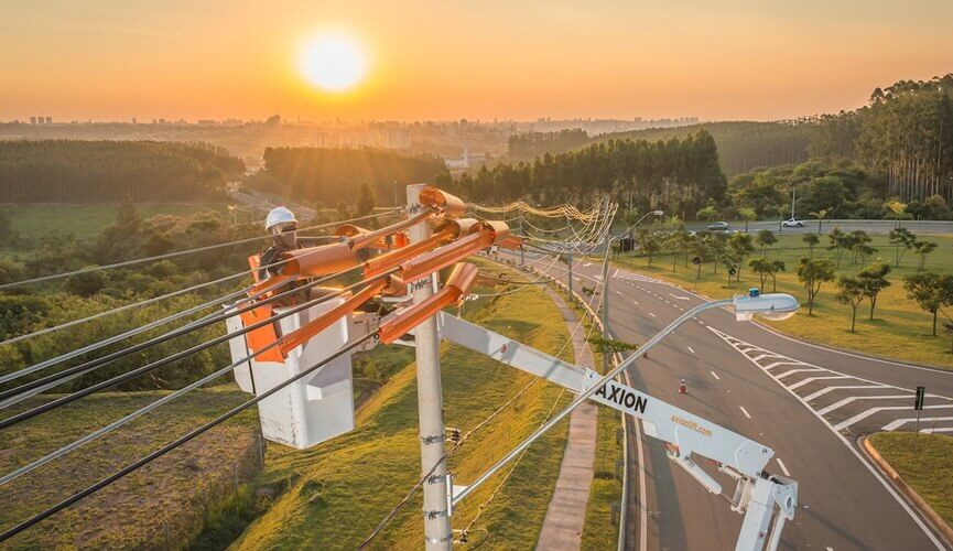 eletricistas em cestas arrumando postes