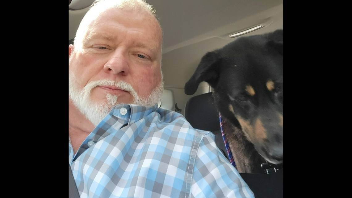 Homem em carro com cachorro