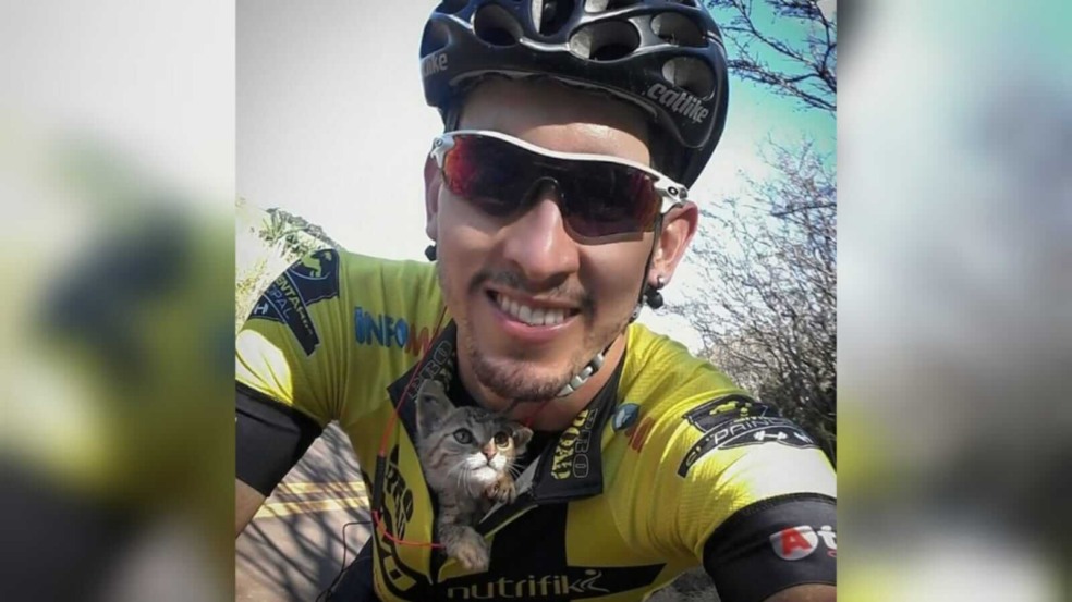 Homem em bicicleta com gato na camiseta