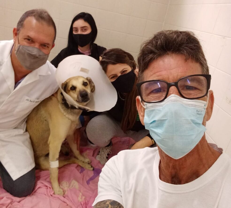 Cachorro com as pessoas que o salvaram
