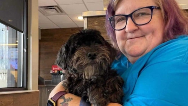 Mulher abraçando cachorro poodle