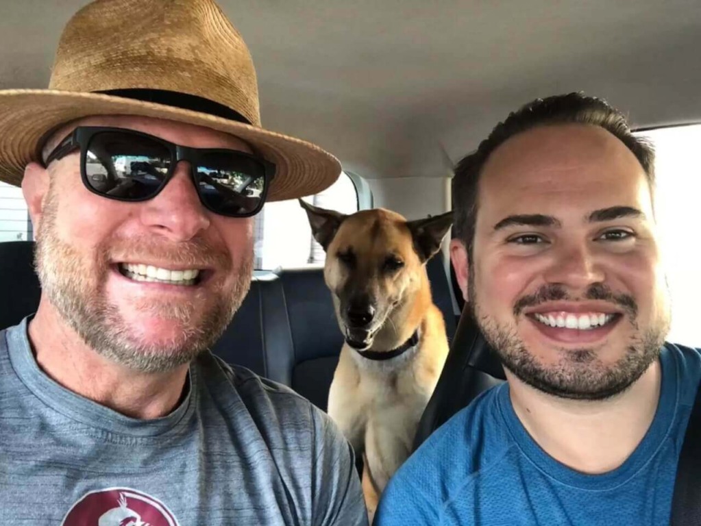 Dois homens e cachorro no carro