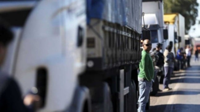 Caminhoneiro ao lado de caminhão