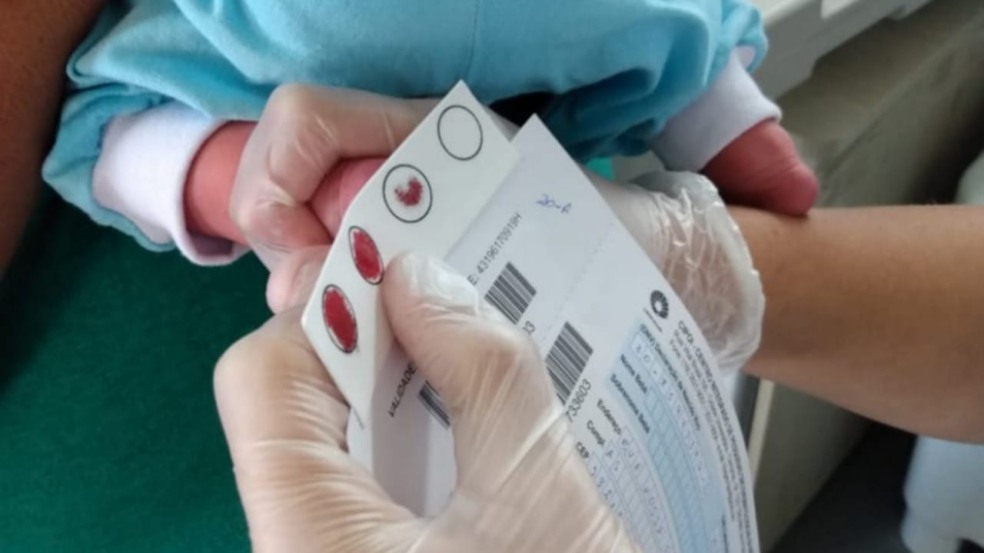 Médica fazendo teste do pezinho em recém-nascido