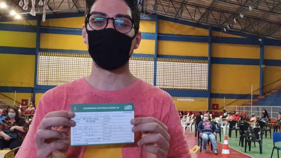 Jovem com cartela de vacinação contra Covid19 em Campo Limpo Paulista