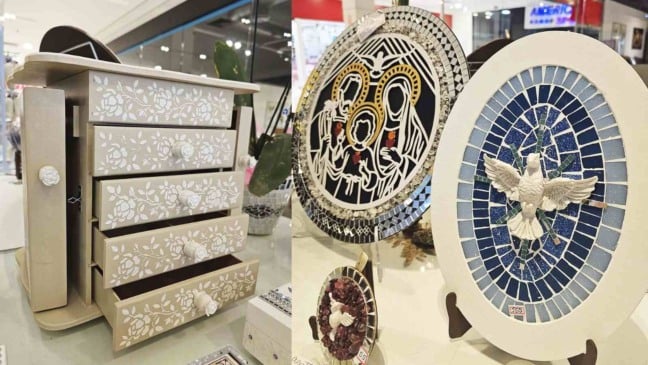 Artesanatos expostos no Espaço Maxi Comunidade em Jundiaí, incluindo um porta-joias em madeira pintado com flores brancas e mosaicos decorativos com temas religiosos e artísticos, à venda em prol da Casa Neemias.