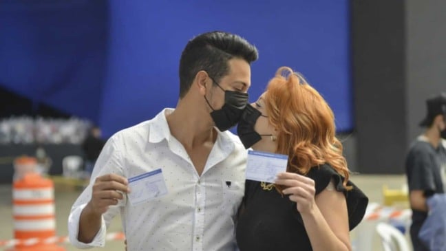 Casal de máscara de beijando