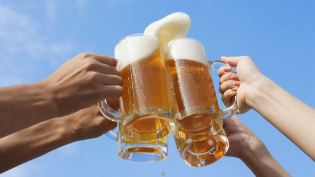 Brinde de cerveja com céu azul ao fundo