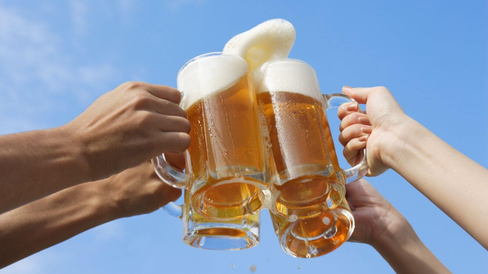 Brinde de cerveja com céu azul ao fundo