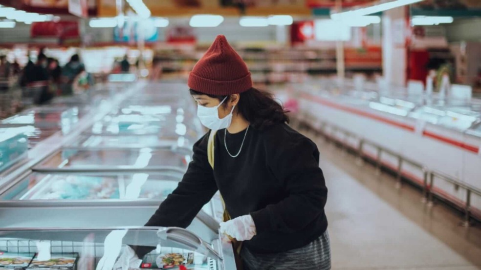 Mulher em supermercado com máscara