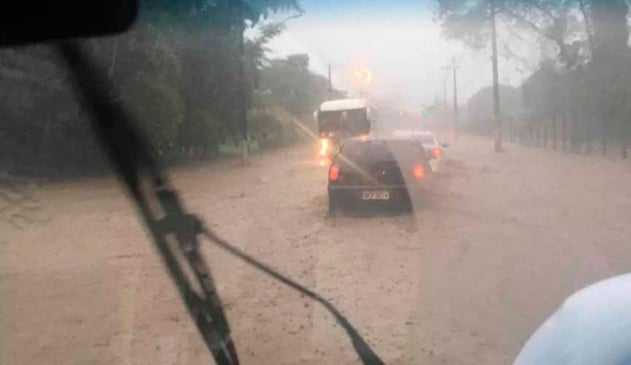 foto de dentro de veículo mostra rodovia alagada e veículos transitando em meio à água