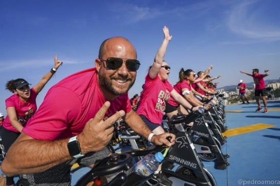 Pessoas de camisetas rosas em bicicletas ergométricas