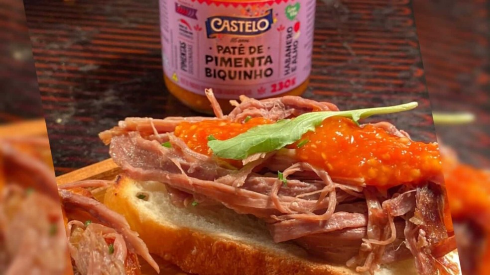 Lanche com patê de pimenta ao fundo