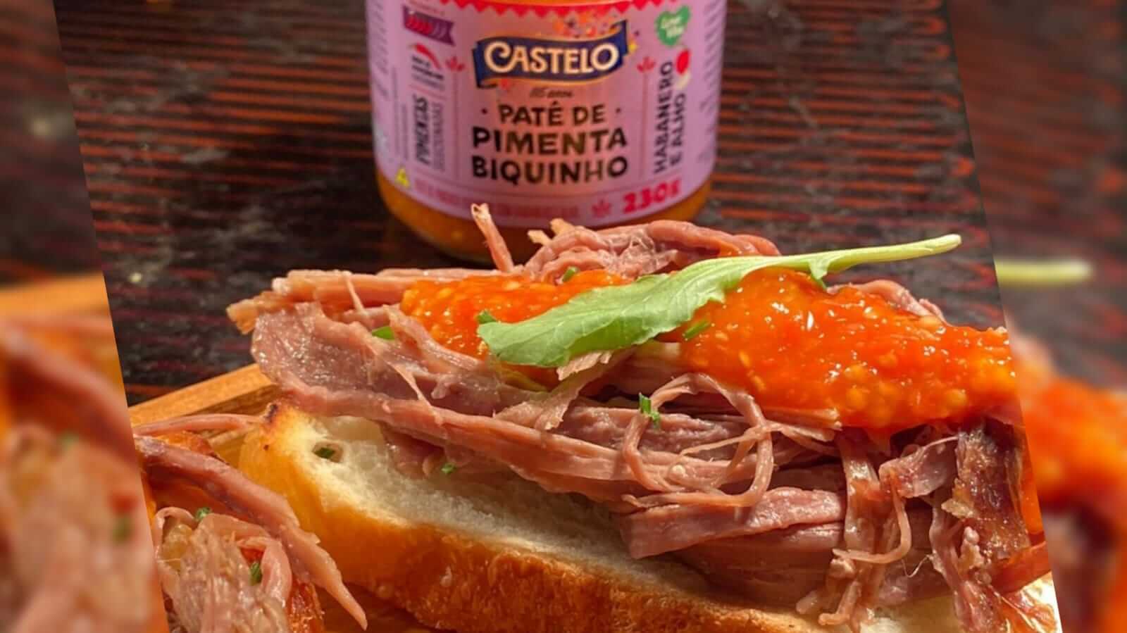 Lanche com patê de pimenta ao fundo