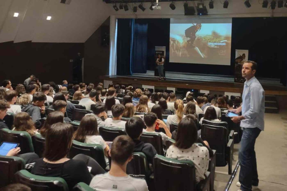 Estudantes assistem a palestra da Copa Colegial de Empreendedorismo em auditório escolar lotado.