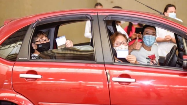 Carro com idosas após vacinação